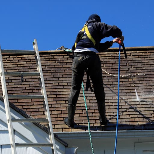 man washing a roof